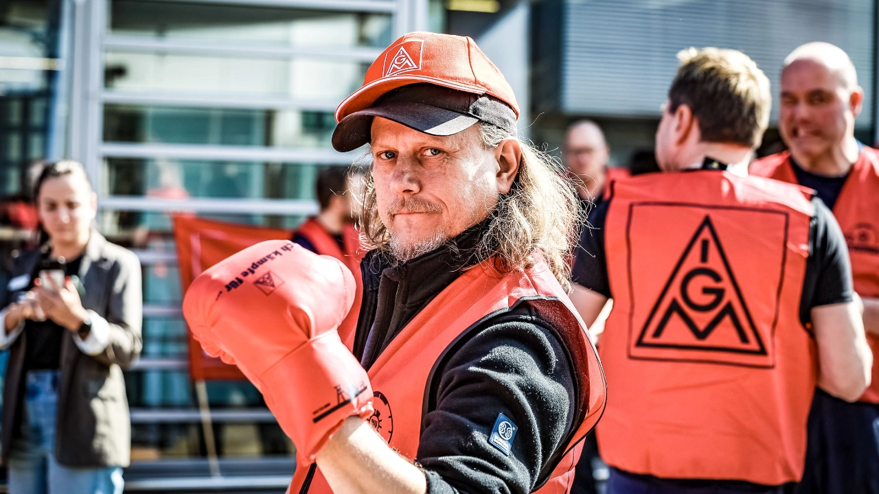 Ein Mann mit rotem Boxhandschuh bei einem Warnstreik in der Kfz-Tarifrunde in Essen