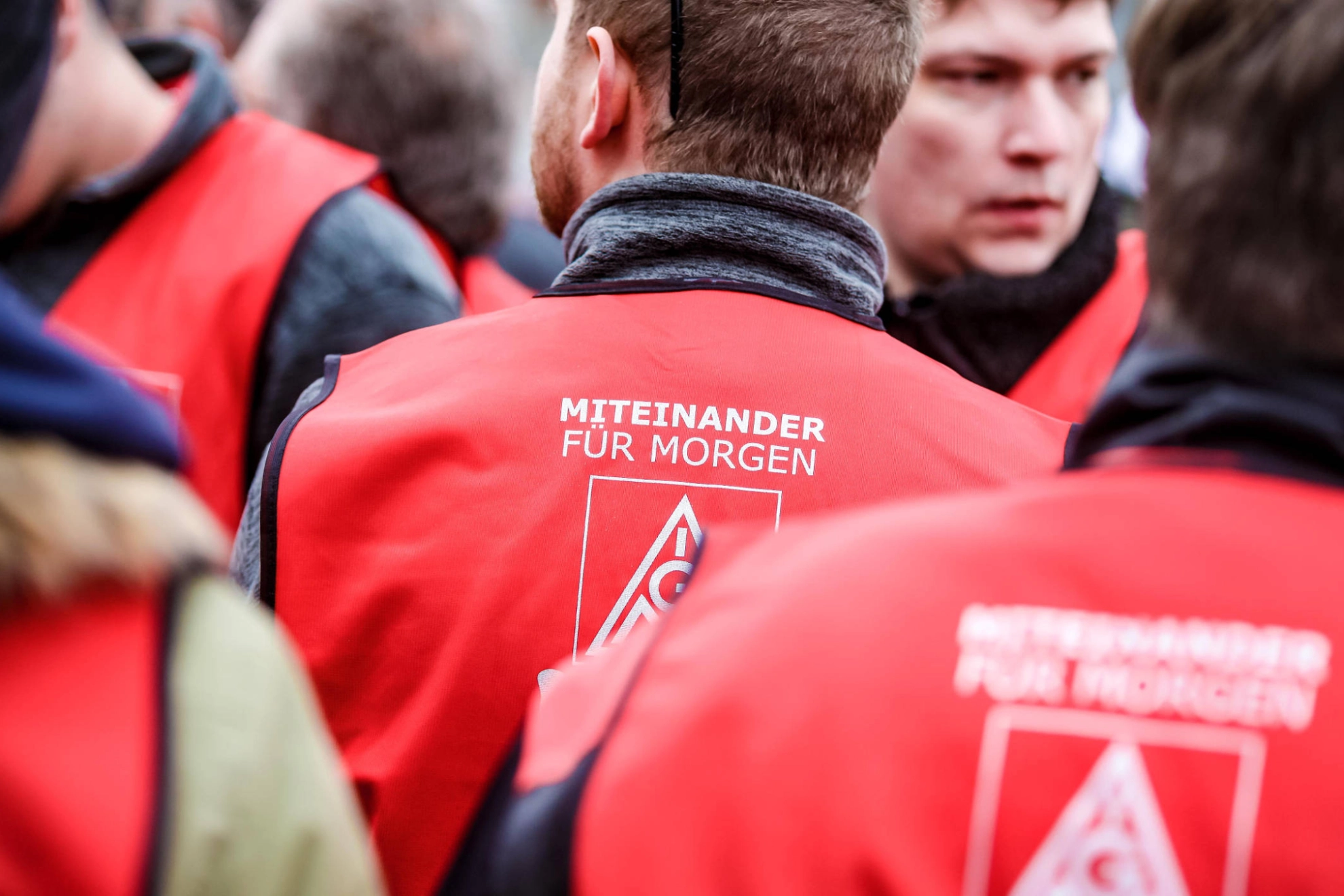 Ein Mann mit einer roten Weste, auf der "miteinander für morgen" steht.