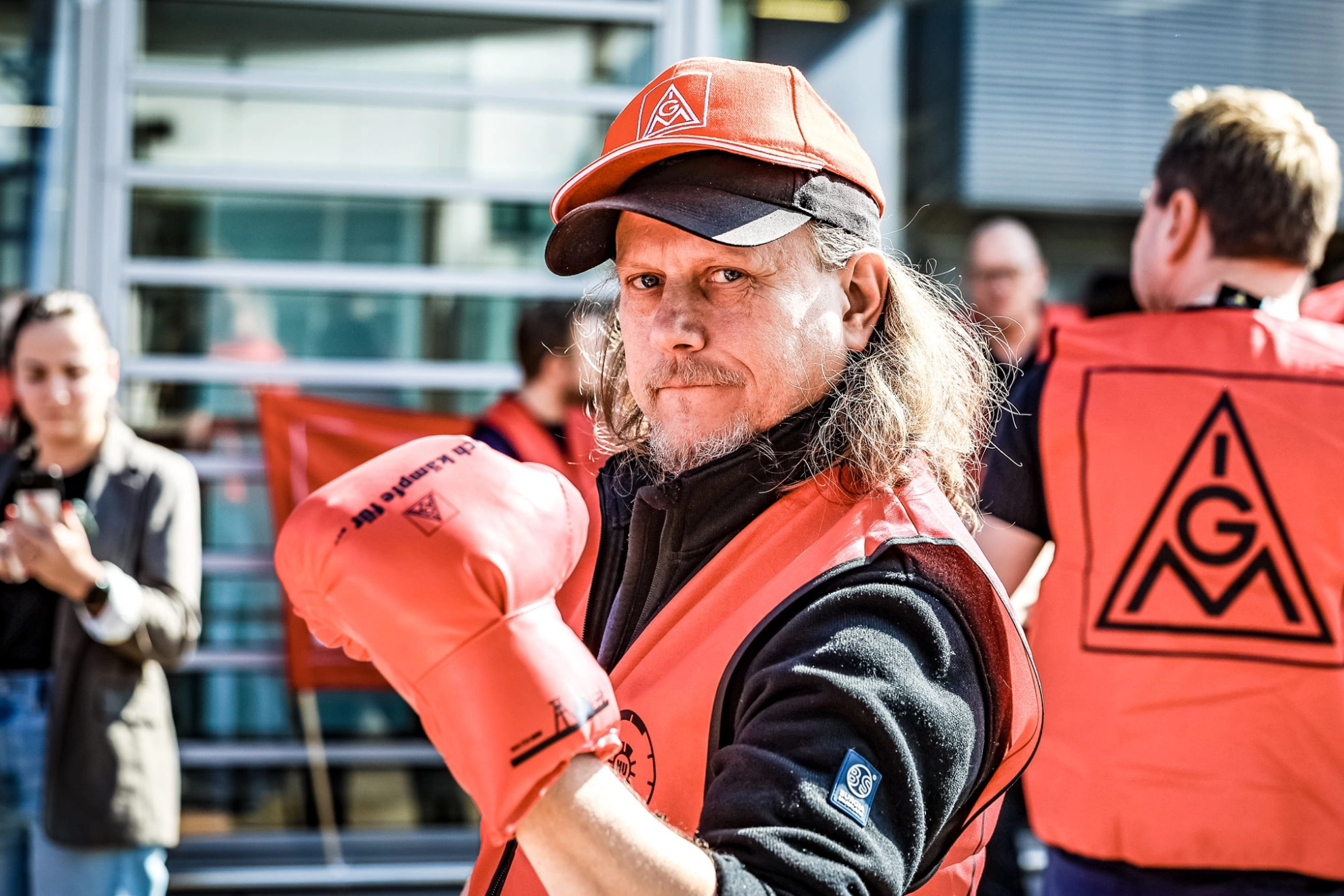 Ein Mann mit rotem Boxhandschuh bei einem Warnstreik in der Kfz-Tarifrunde in Essen